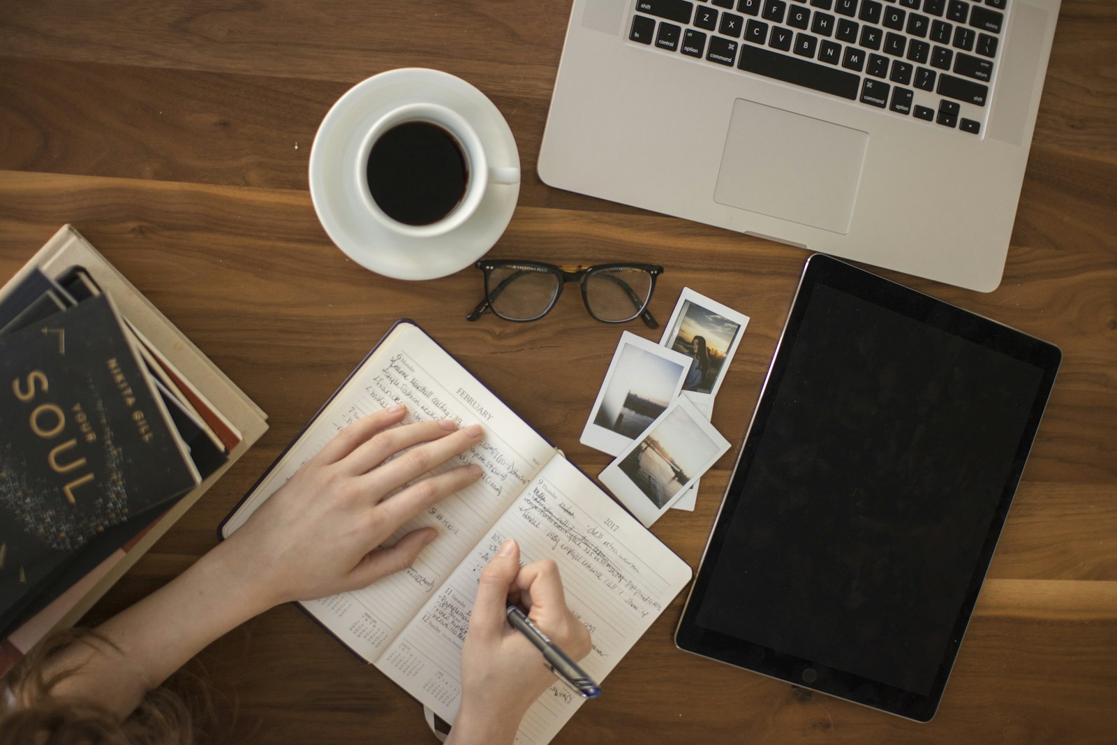Writing at a tidy desk with a laptop, notebook and coffee